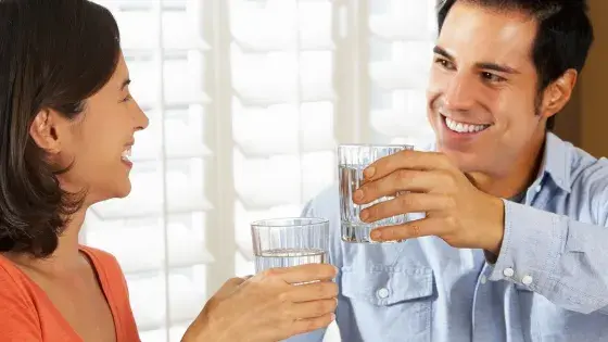 man and woman clinking glasses