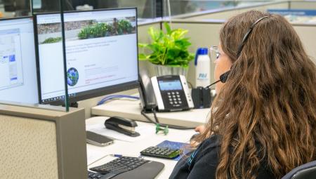 A woman facing a computer screen while on a support call.